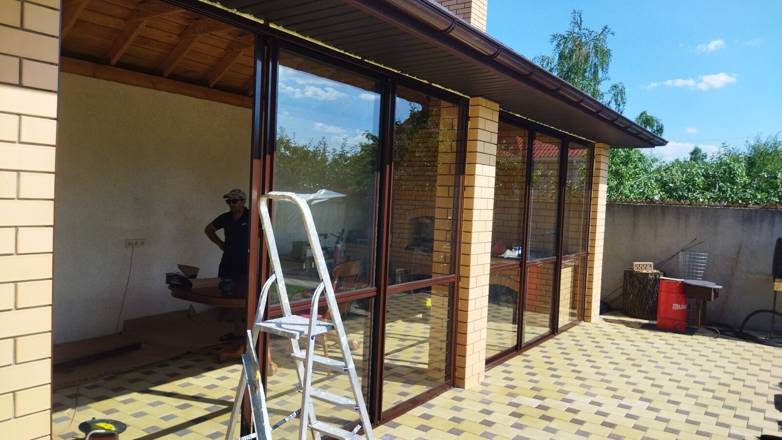 Раздвижные конструкции для террасы жилого дома с энергосберегающими стеклопакетами. Вид снаружи. Воронеж, лето 2024 года.